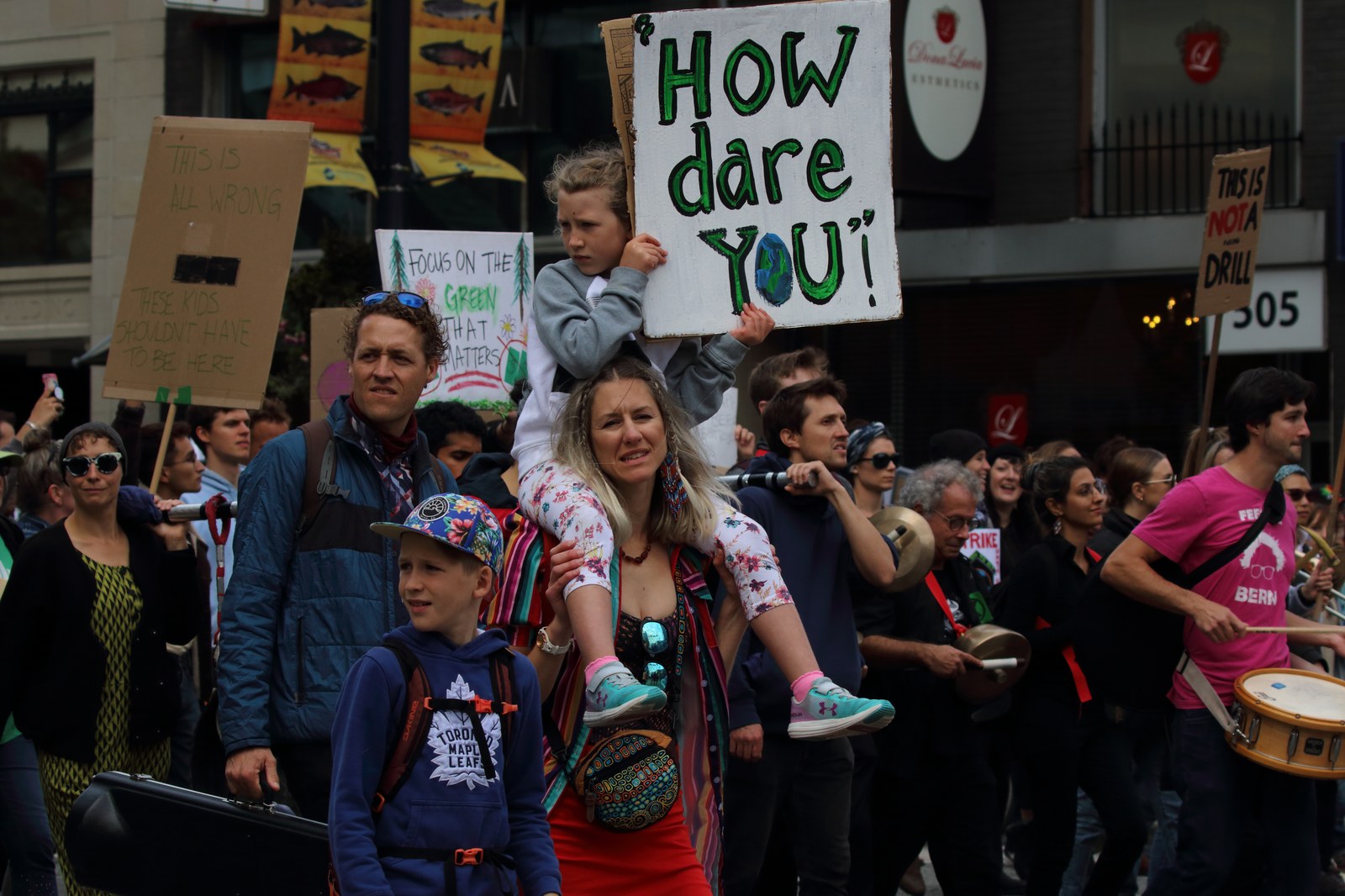 Climate marchers carrying a hand-painted 'How dare you' placard