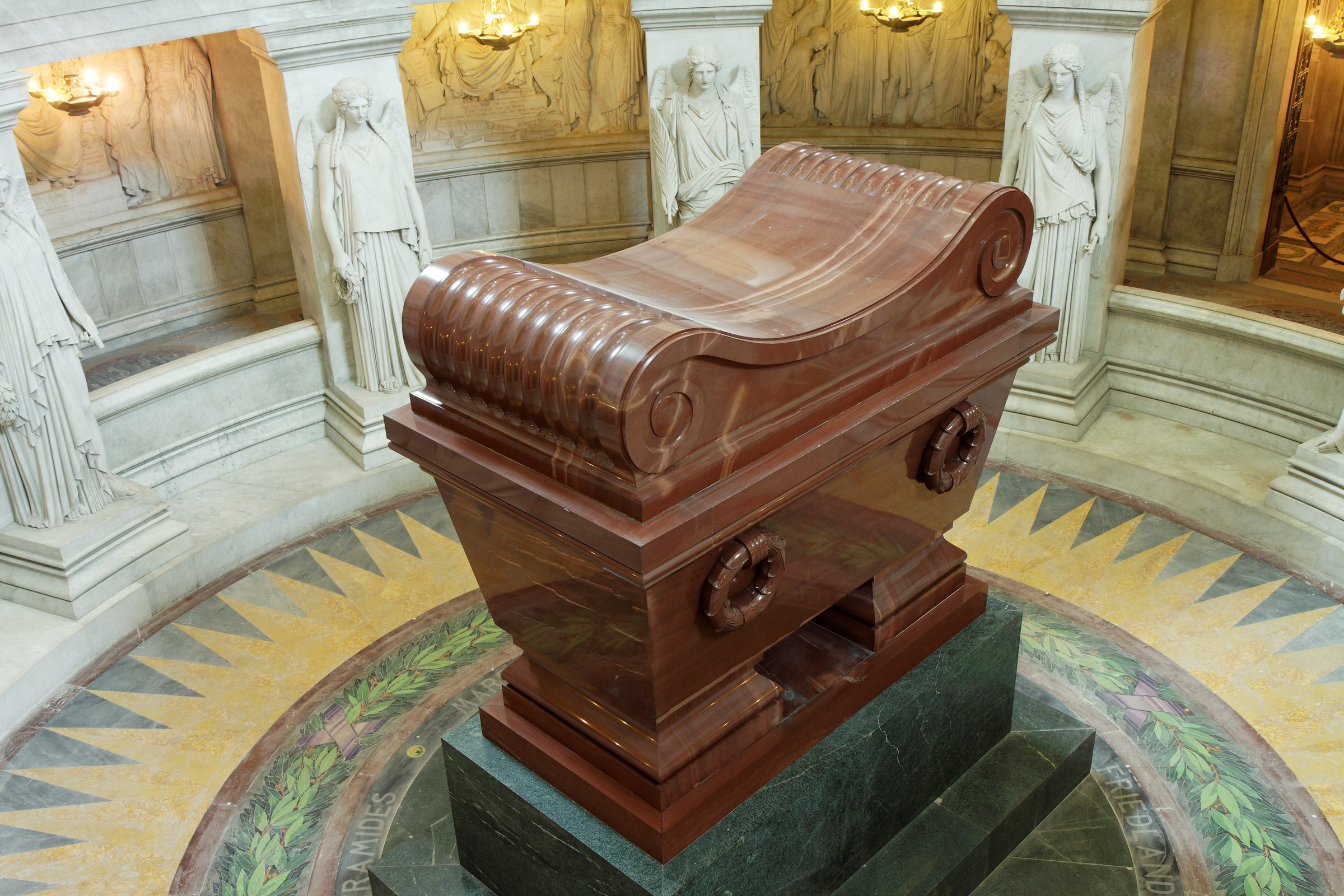 The tomb of Napoleon beneath the dome of Les Invalides in Paris: a red porphyry sarcophagus on a green granite base in the circular crypt