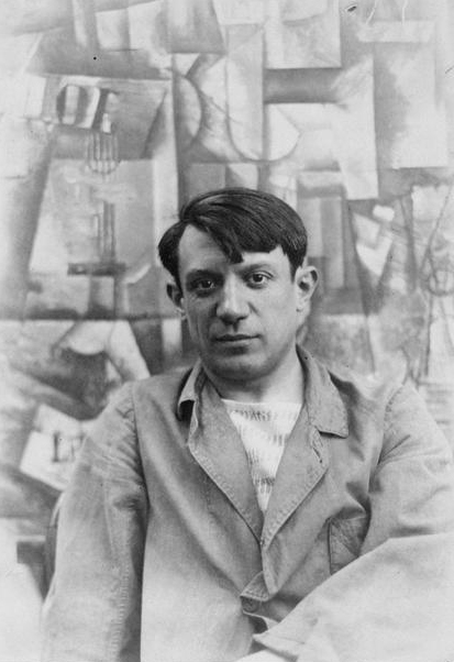 Pablo Picasso, summer 1912, photographed in front of his painting The Aficionado