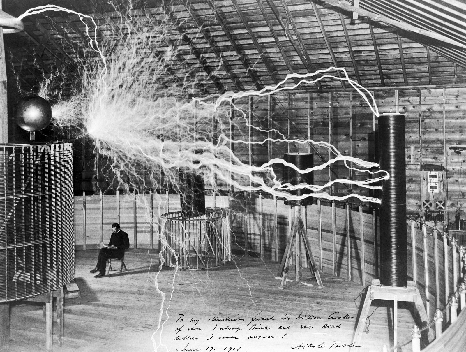 Nikola Tesla seated in his laboratory amid electrical discharges, in a famous double-exposure photograph