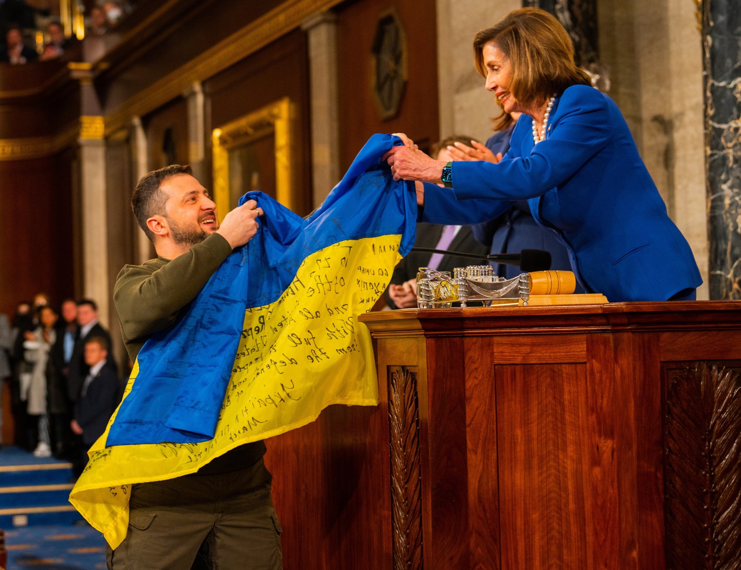 Volodymyr Zelenskyy with Nancy Pelosi holding a Ukrainian flag in the U.S. Capitol, 21 December 2022